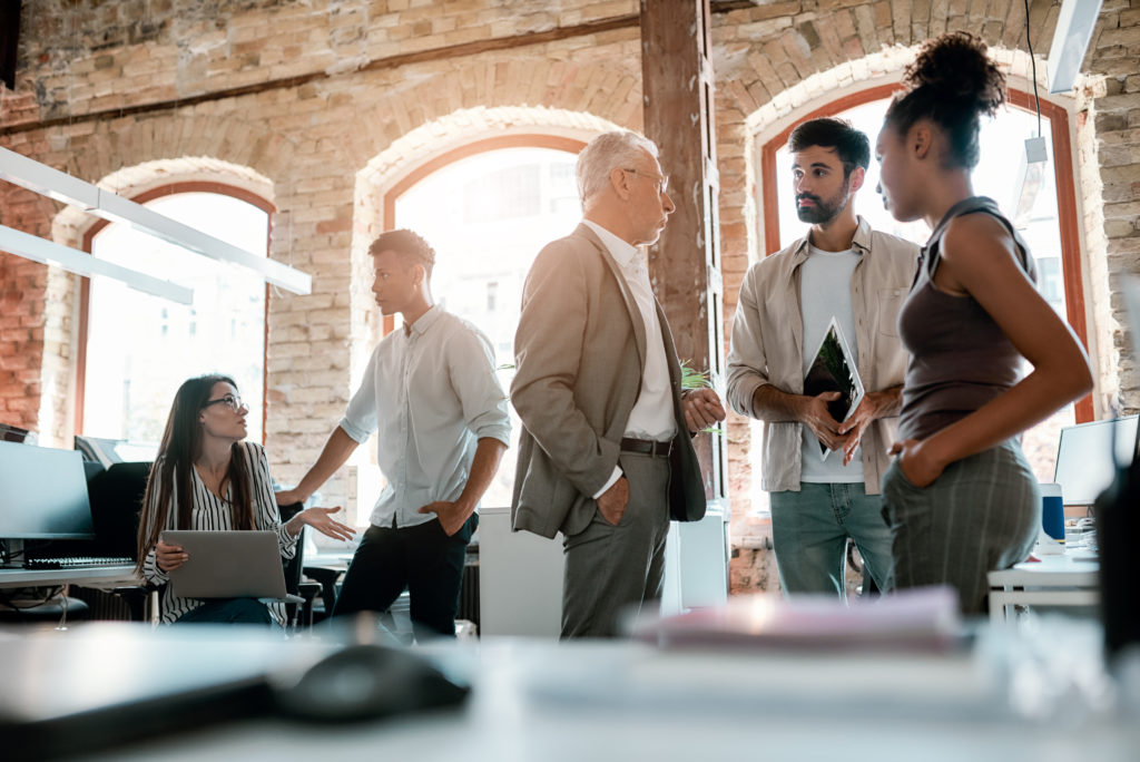 office life. group of modern people talking with each other and discussing business ideas while standing in the creative office